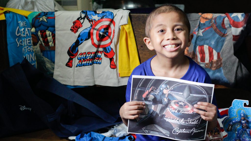 Wish Kid Xander posing with his gifts from Disney Philippines