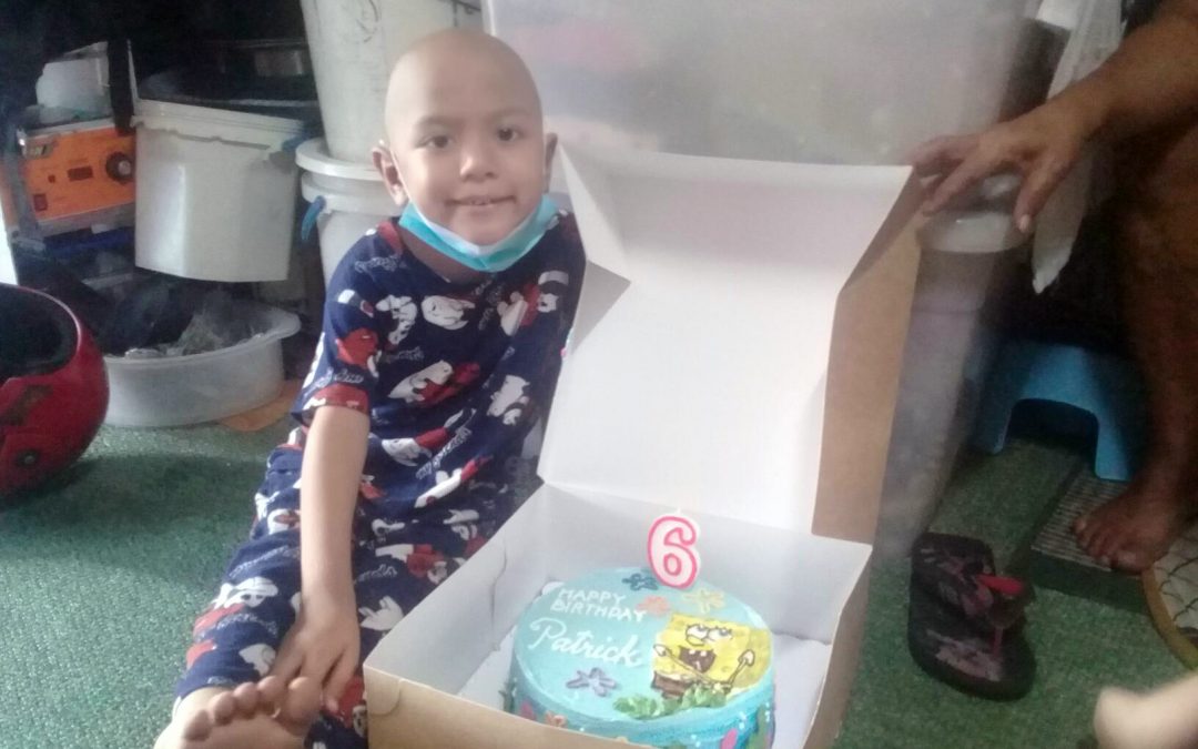 Wish kid posing with a birthday cake made by a corporate partner of Make-A-Wish Philippines
