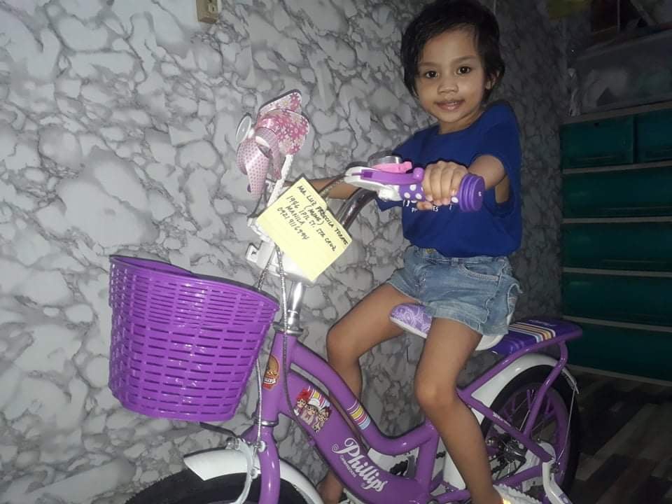 Wish kid Ming posing with her new purple bike - other kids had their wishes granted as well!