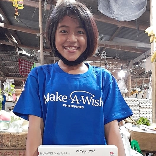 Wish Kid Rein is all smiles while holding her new tablet
